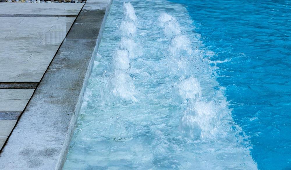 Blue Water Pool Surface With Sunlight Reflections
