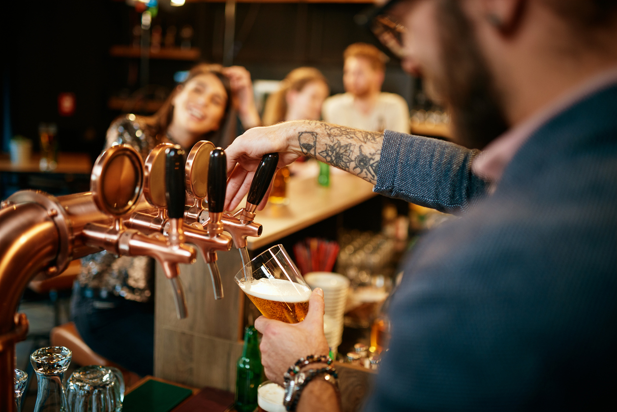 Barman filling pint of beer in glass