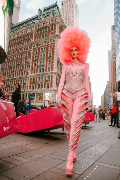 Woman in red and white floral sleeveless dress standing on white floor tiles