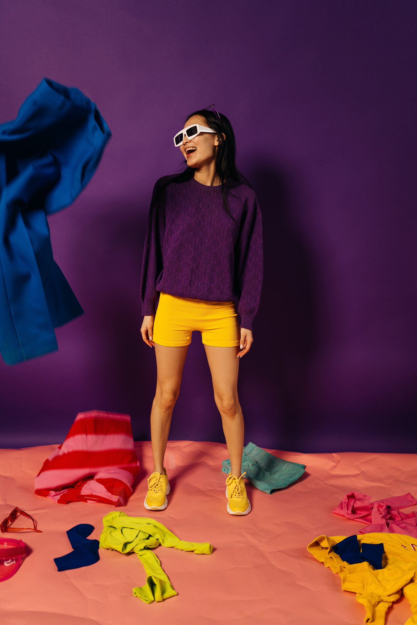 A woman wearing yellow bike shorts and a purple oversize sweater