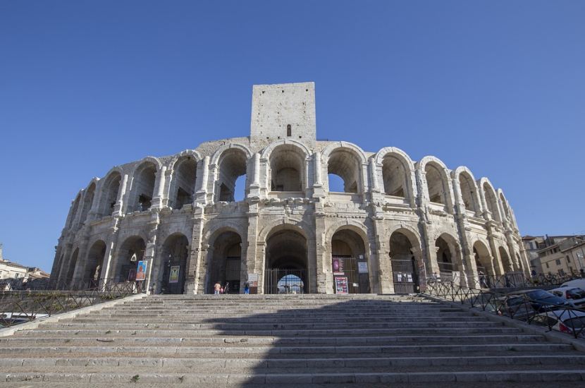 Arles Amphitheatre, a big theater, white theater, blue sky, cars