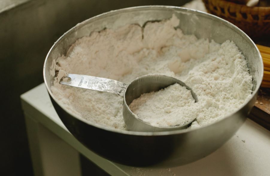 a bowl with flour and a dry measuring cup