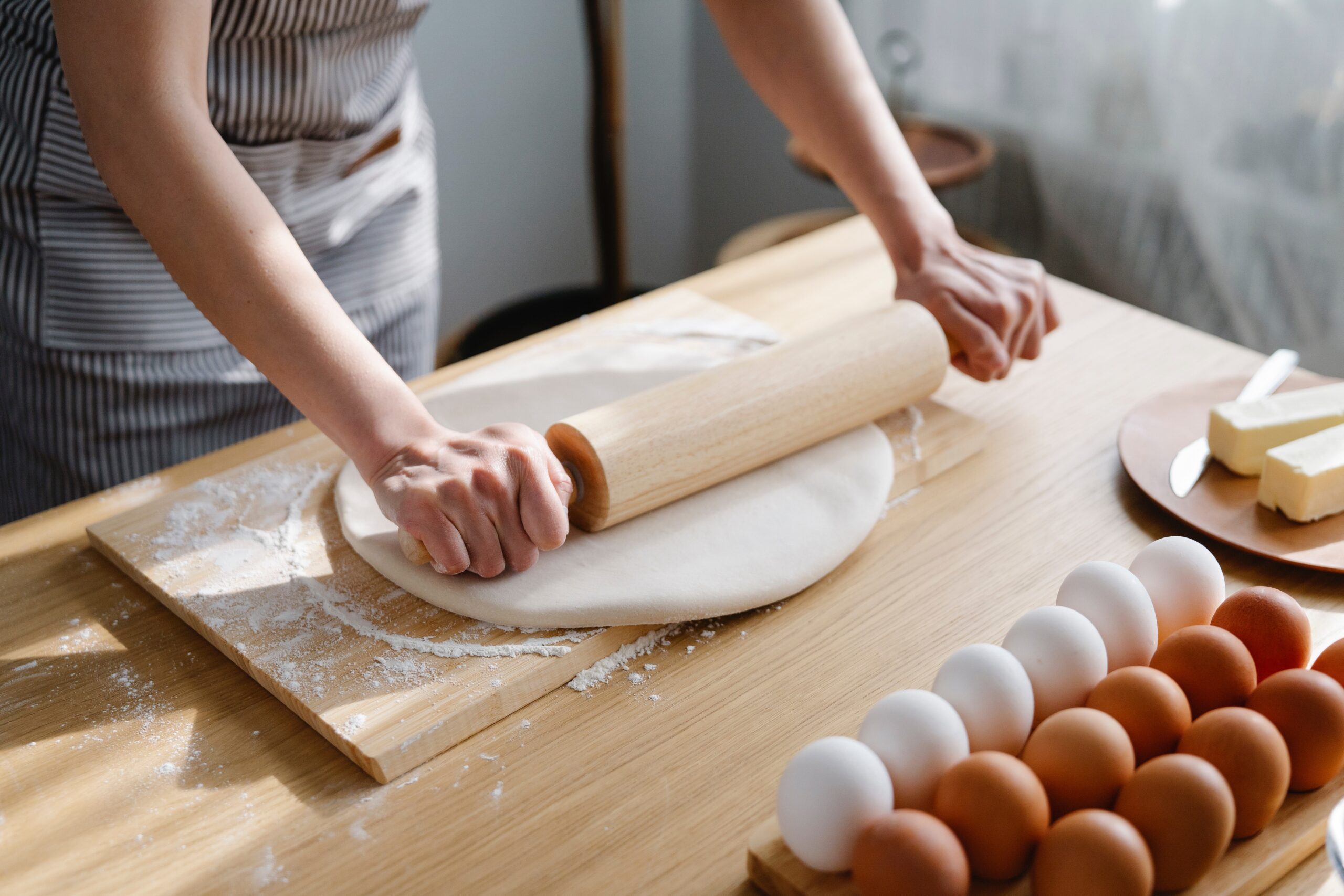 woman rolling dough with a rolling pin