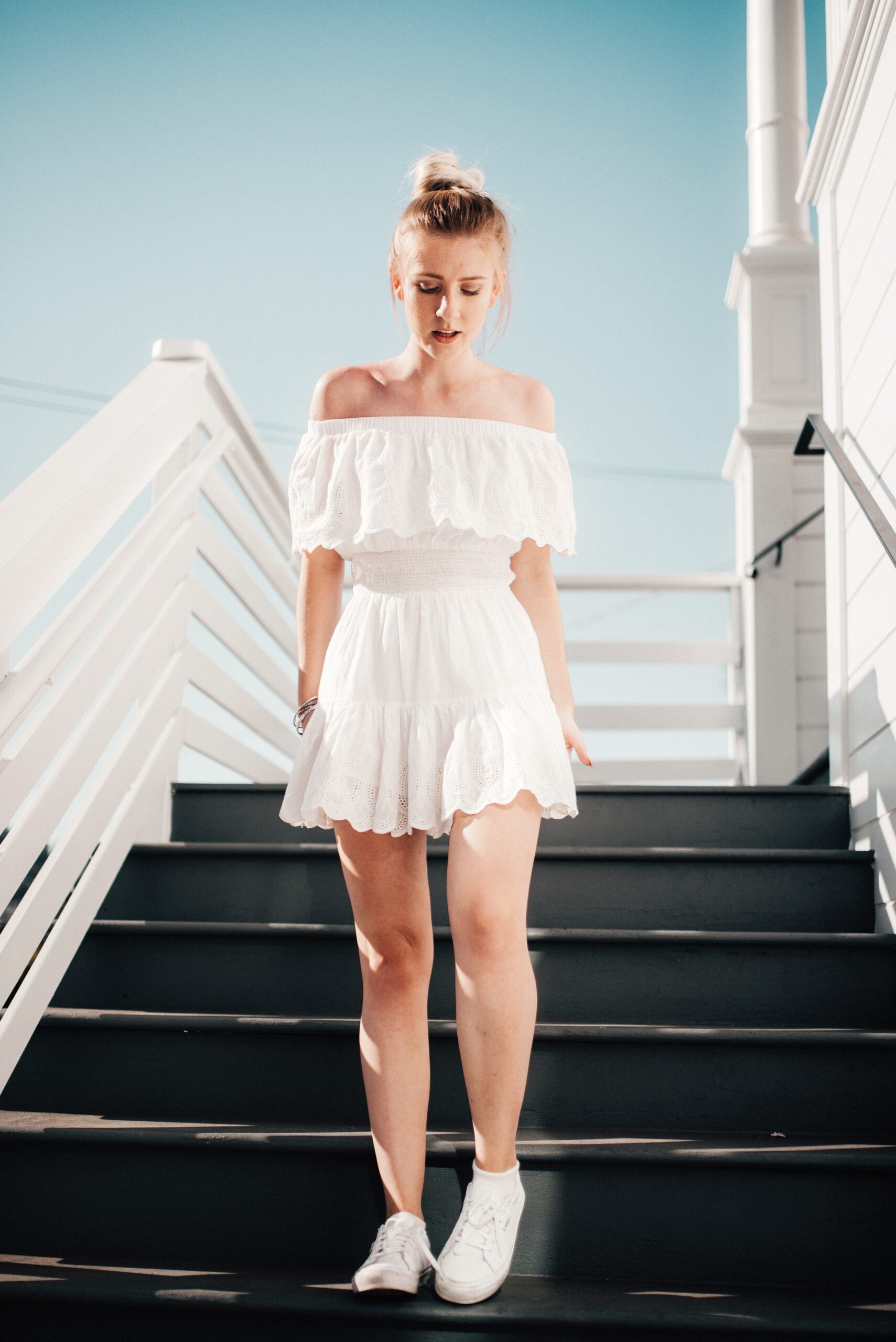 Woman walking downstairs wearing a white pirate-inspired dress